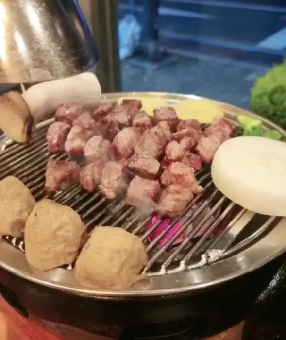 숯불 위에서 지글지글 익어가는 두툼한 고기 덩어리들