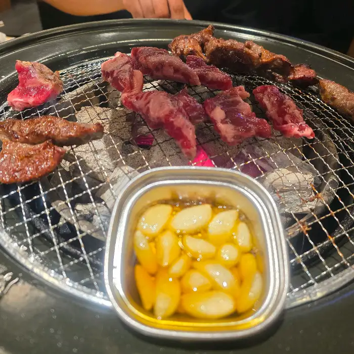 화로구이 불판 위에 올려진 마늘 소갈비살과 숯불