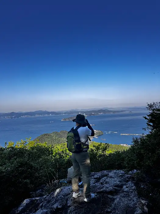 등산객이 산 정상에서 풍경을 바라보는 모습