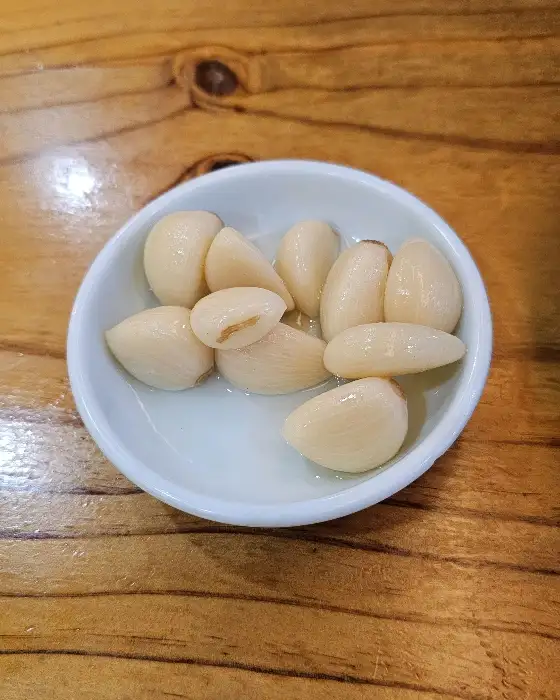 작은 접시에 담긴 하얗고 뽀얀 마늘 절임