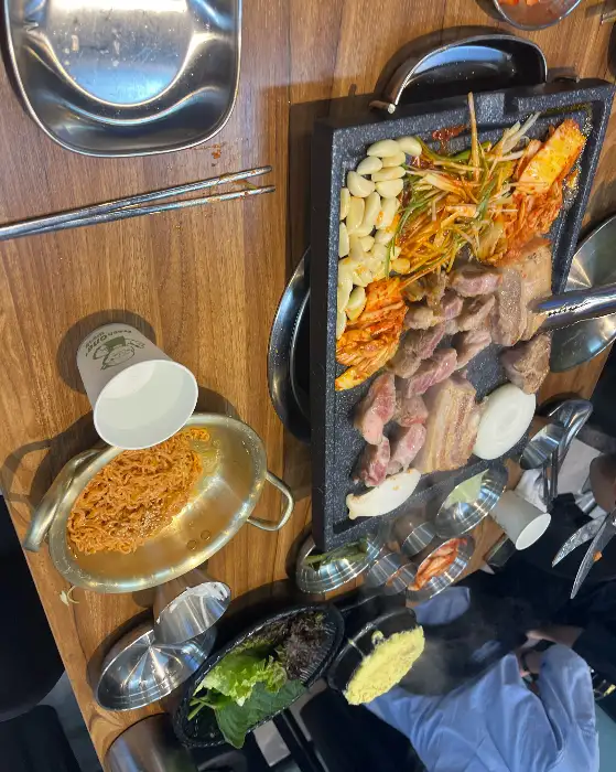 잘 익은 삼겹살 조각을 젓가락으로 집어 올리는 모습