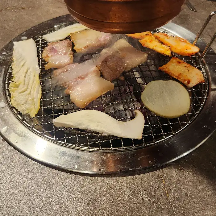 숯불 위에서 익어가는 삼겹살과 팽이버섯, 감자, 그리고 갓김치