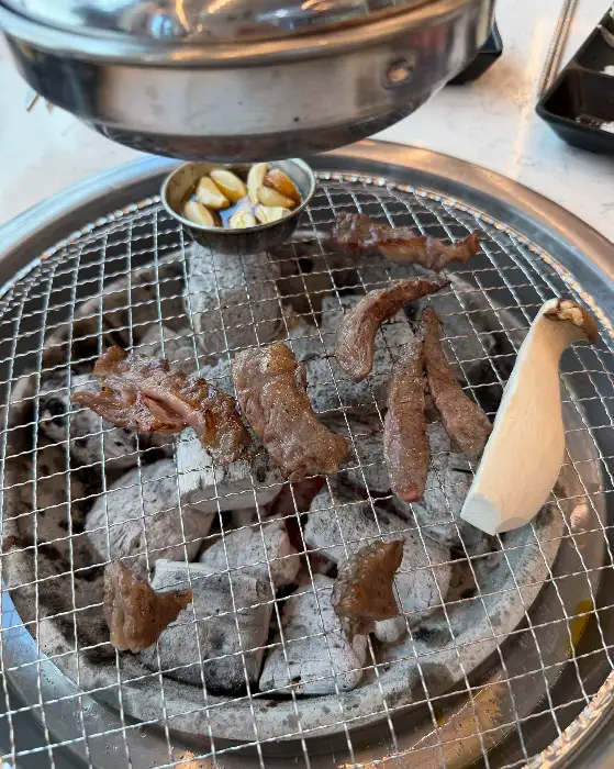 숯불 위에서 익어가는 갈비살과 버섯, 마늘