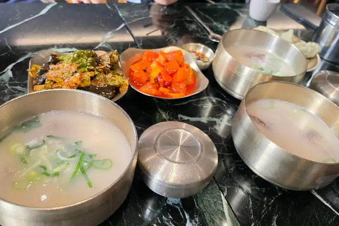 테이블 위에 차려진 설렁탕과 반찬들