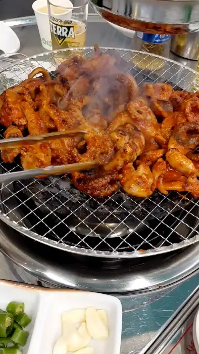 잘 구워진 쭈꾸미를 집는 모습
