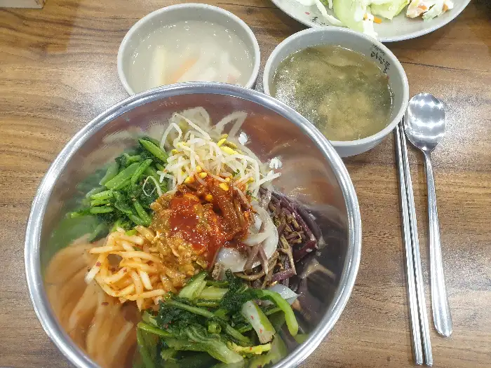 다양한 나물과 밥이 담긴 비빔밥 그릇과 국물