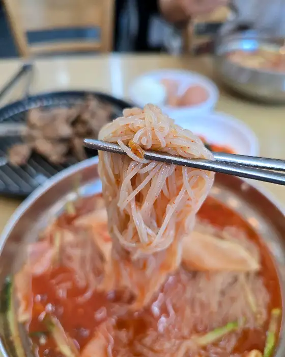 집게로 집어 올린 냉면 면발