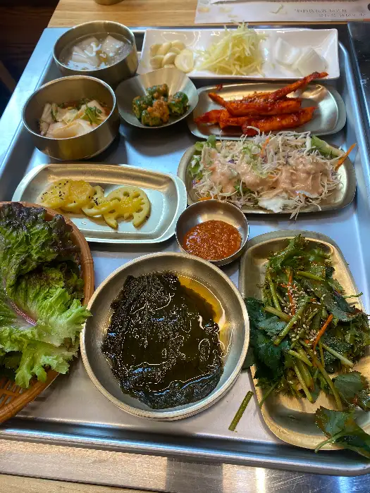 다양하고 정갈한 밑반찬이 테이블 위에 차려져 있습니다.