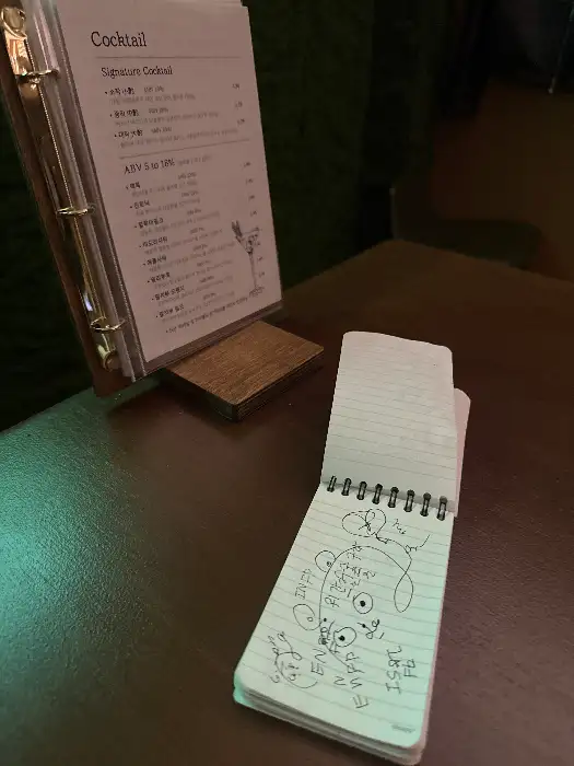 칵테일 메뉴판과 낙서가 그려진 노트