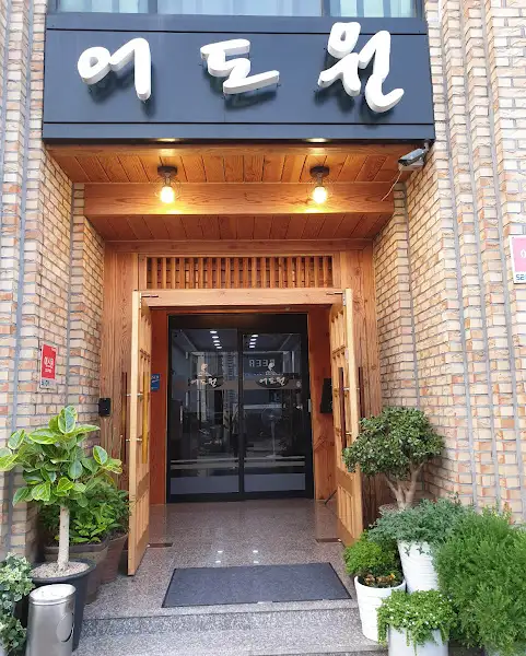 식당의 입구. 나무로 된 문이 활짝 열려 있고, 안쪽으로 보이는 내부 공간이 깔끔하다. '어원'이라는 간판이 입구 위에 걸려 있다.