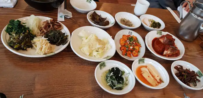 테이블에 여러 가지 나물 반찬과 메인 요리