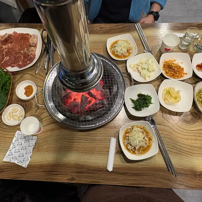 숯불 위에서 구워지고 있는 돼지갈비와 함께 나온 다양한 밑반찬들