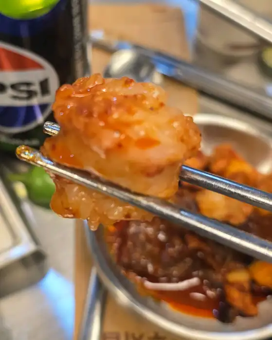 젓가락으로 집어 올린 곱창의 단면이 보인다.