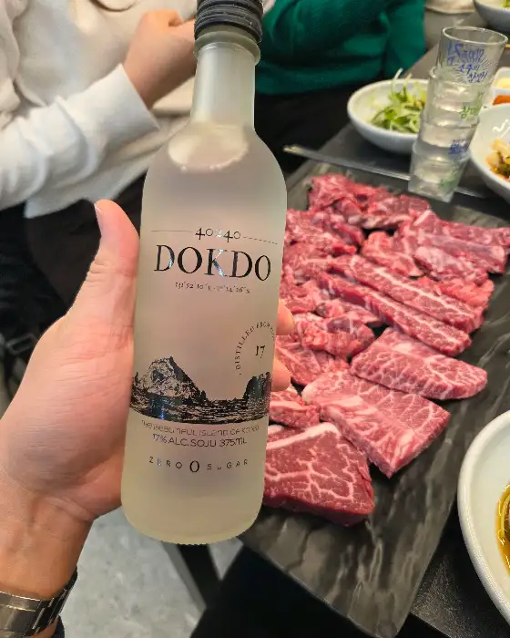 병에 담긴 울릉도 독도 소주와 함께 놓인 칡소 고기