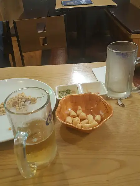 맥주잔과 뻥튀기 과자가 놓인 테이블 모습