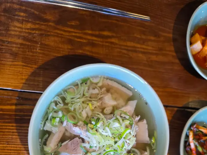 정갈하게 담긴 맑은 돼지국밥 한 그릇과 곁들임 반찬들