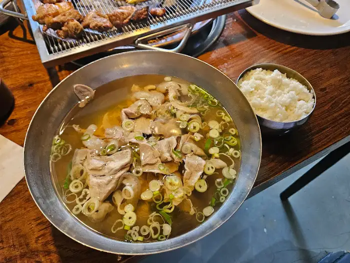 큰 그릇에 담긴 뽀얀 곰탕의 모습. 큼직한 고기 조각들과 파가 보기 좋게 담겨 있다.