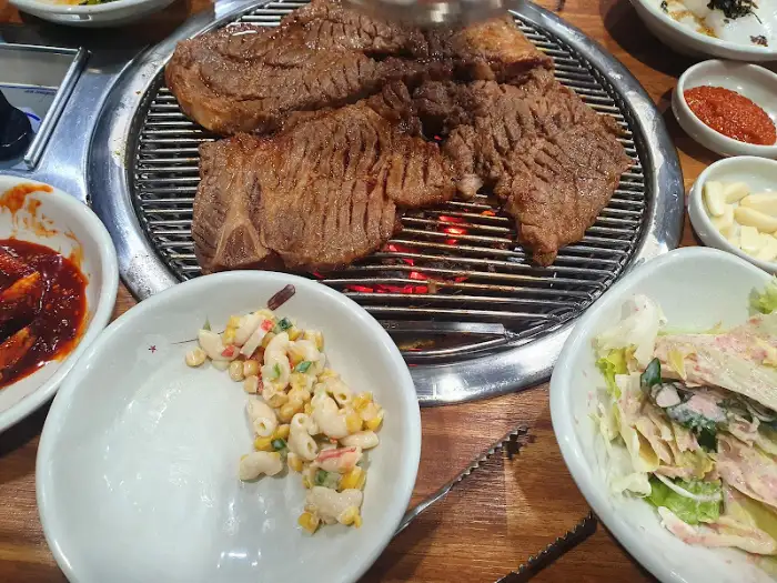 테이블에 차려진 푸짐한 돼지갈비와 여러 밑반찬들. 먹음직스러운 모습입니다.
