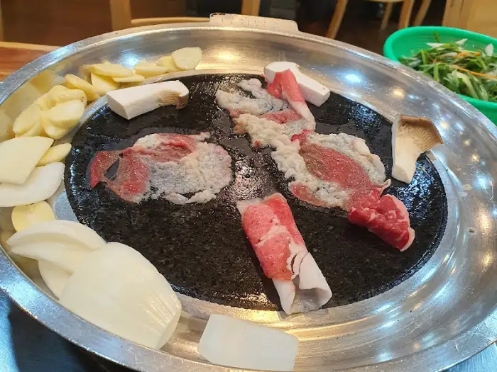 불판 위에서 익어가는 소고기와 곁들임 재료