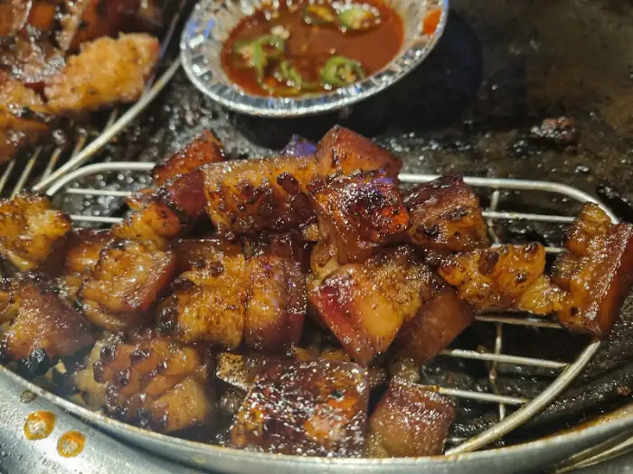 잘 구워진 삼겹살 조각과 소스