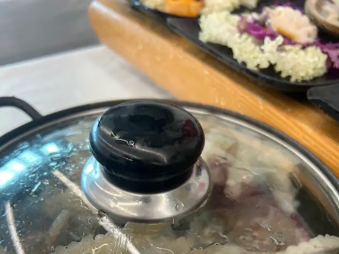 조개탕이 끓고 있는 냄비 뚜껑이 덮여 있는 모습