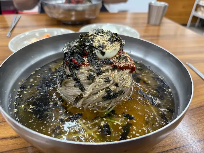 푸짐한 고명으로 덮인 시원한 물막국수