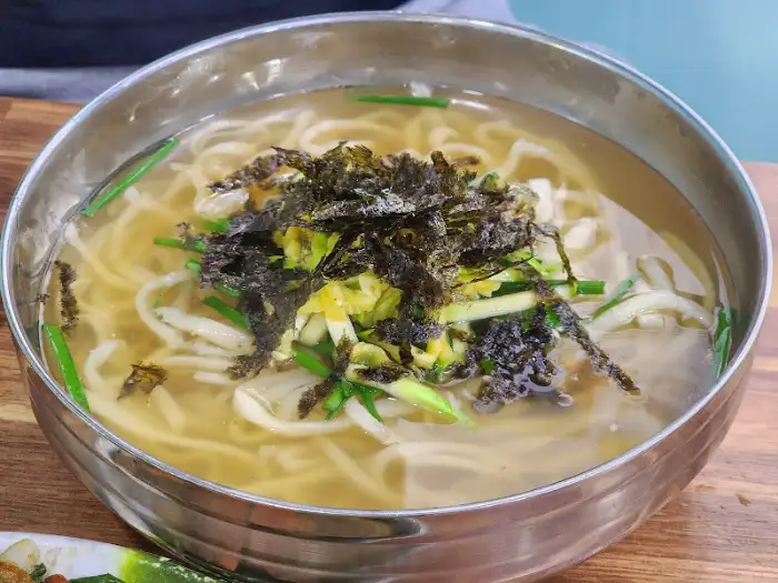 따뜻한 국물 위에 김가루와 파가 듬뿍 올라간 칼국수 한 그릇