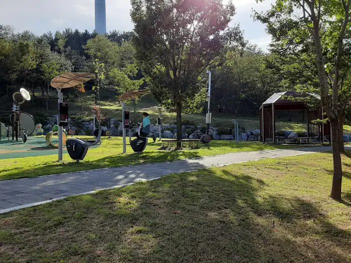 놀이터 시설과 산책로, 나무가 어우러진 공원 풍경.