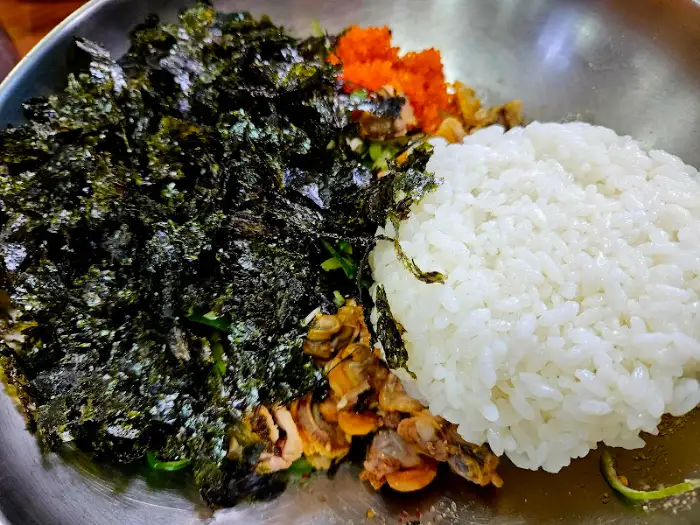 밥과 김, 꼬막살이 푸짐하게 담긴 꼬막 비빔밥 재료