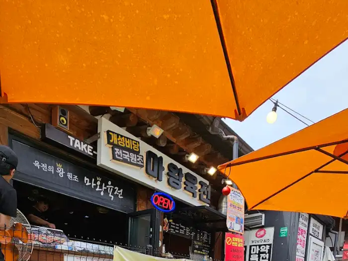 오렌지색 파라솔 아래 마왕육전 간판