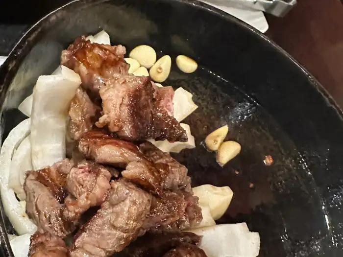 팬에 익은 고기와 마늘, 양파 조각