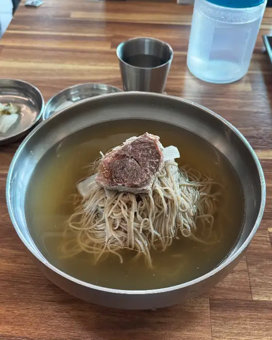 테이블 위 나무 질감과 함께 보이는 평양냉면