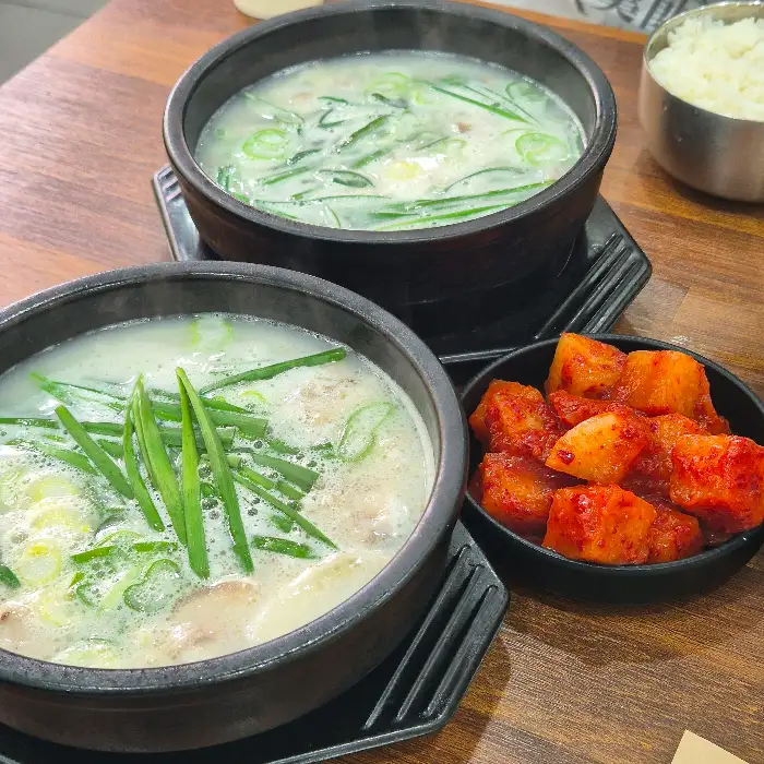 두 개의 국밥 그릇과 깍두기 접시가 테이블 위에 놓여 있는 모습.