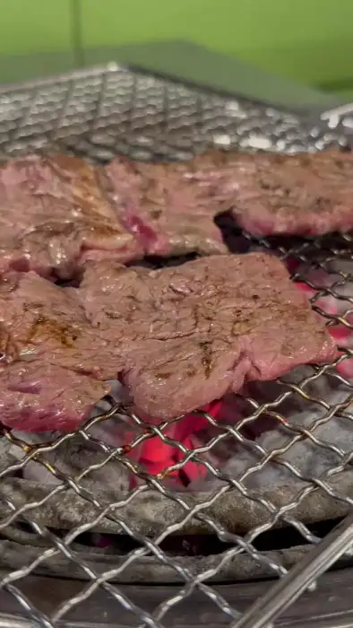 숯불 위에서 맛있게 구워지고 있는 두툼한 고기 조각들.