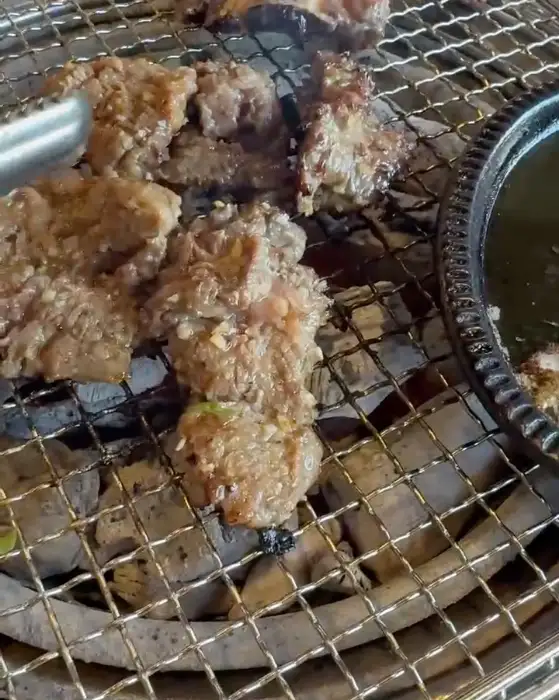 양념에 버무려져 숯불 위에서 구워지고 있는 갈비 조각들.