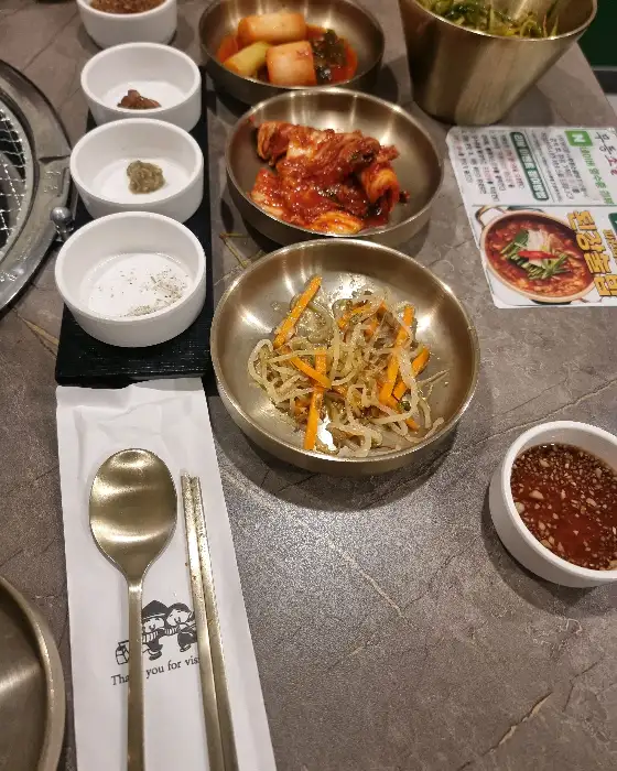 여러 가지 소스가 담긴 작은 그릇들과 쌈 채소