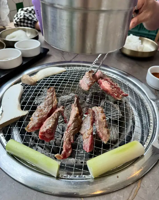 숯불 위에서 익고 있는 소갈비와 곁들임 채소