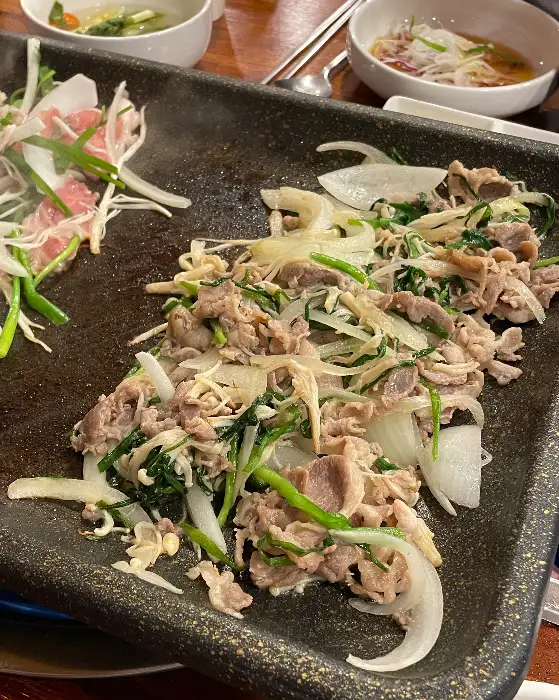 불판 위에 산더미처럼 쌓인 오리고기와 채소