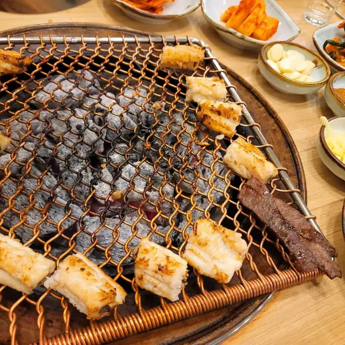 숯불 위에서 구워지고 있는 장어 조각들