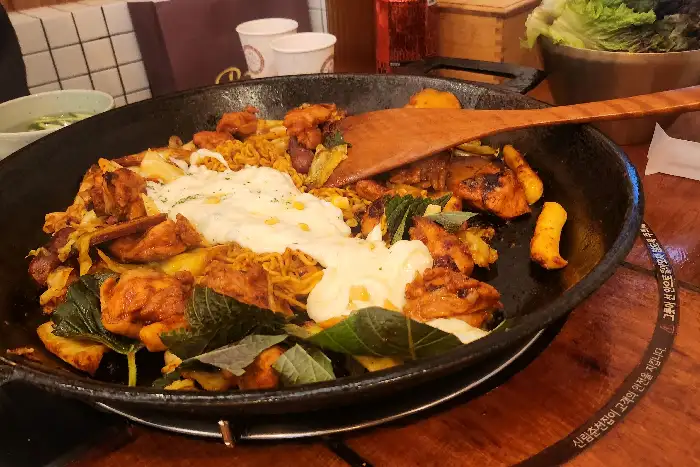 치즈를 듬뿍 얹어 녹이고 있는 닭갈비