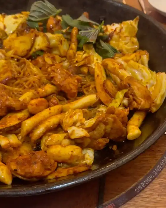 푸짐하게 담겨 나온 닭갈비, 다양한 사리와 야채가 어우러져 있습니다