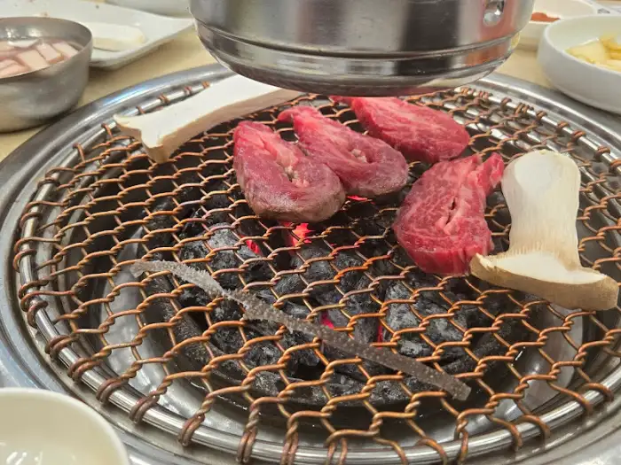 숯불 위에서 익어가는 소고기와 버섯
