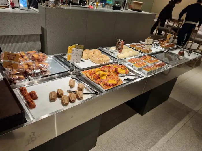 카페의 베이커리 코너를 촬영한 사진. 다양한 종류의 빵과 케이크가 진열되어 있다.