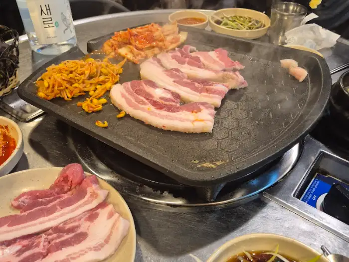 뜨겁게 달궈진 불판 위에 올라간 먹음직스러운 삼겹살