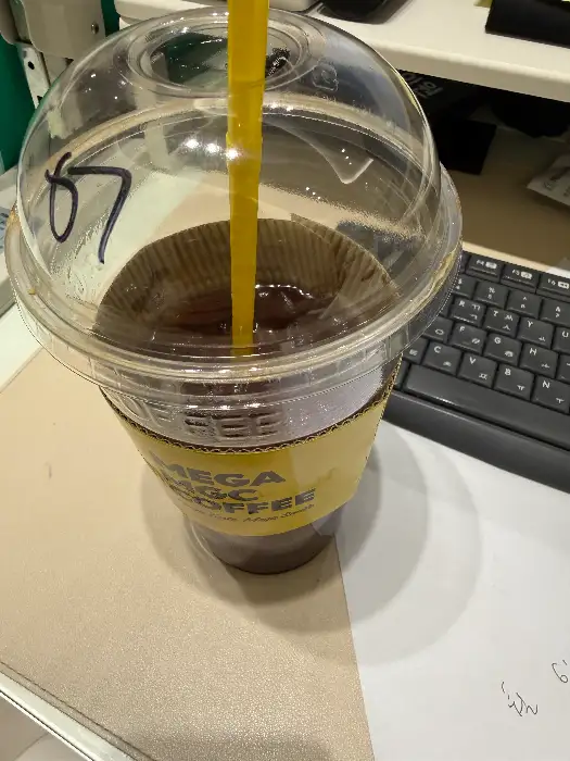 아이스 아메리카노가 담긴 투명 컵과 컵 홀더.