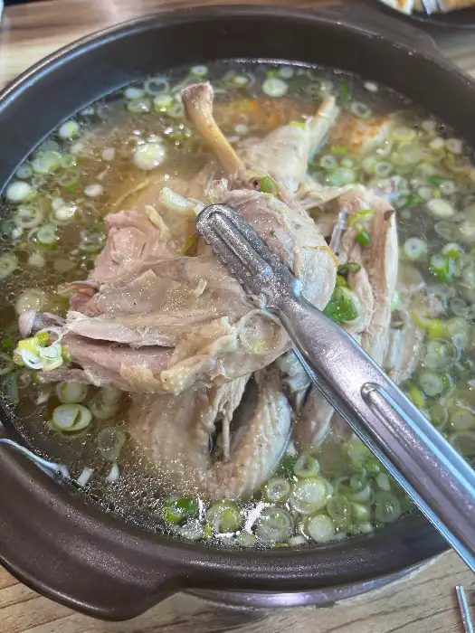 커다란 뚝배기 안에서 끓고 있는 오리백숙의 모습