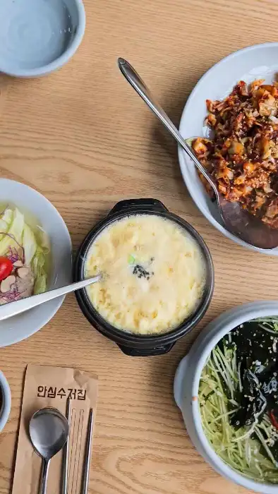 따뜻하게 김이 나는 계란찜과 옆에 놓인 오이냉국, 그리고 상추 등 곁들임 반찬들.