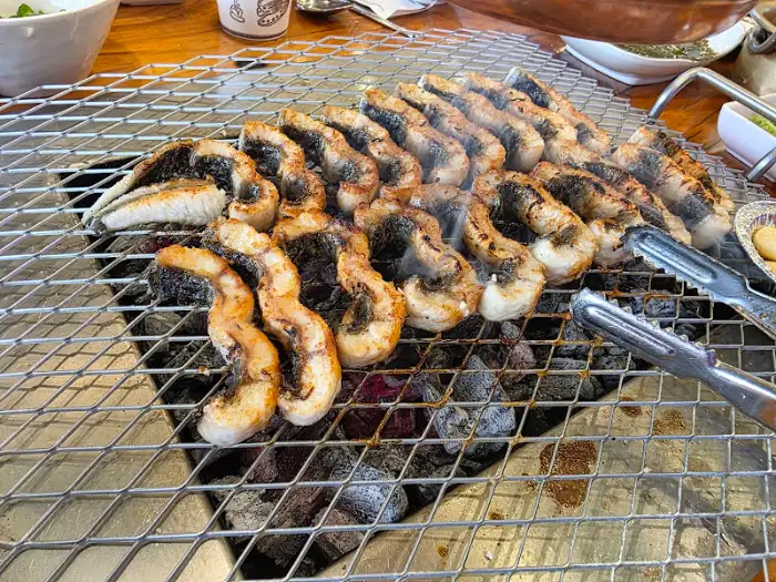 잘 익은 장어 조각들이 숯불 위에서 빛나고 있는 모습