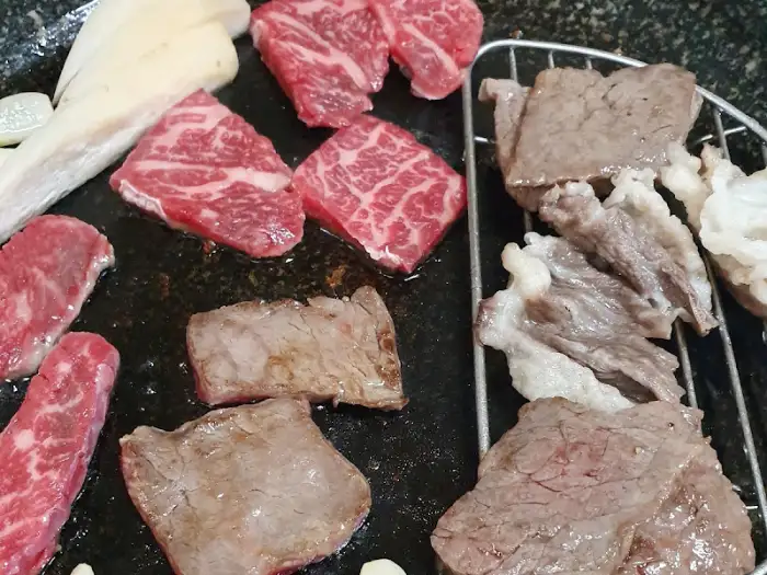 다양한 부위의 고기 조각들이 불판 위에서 익어가고 있는 모습