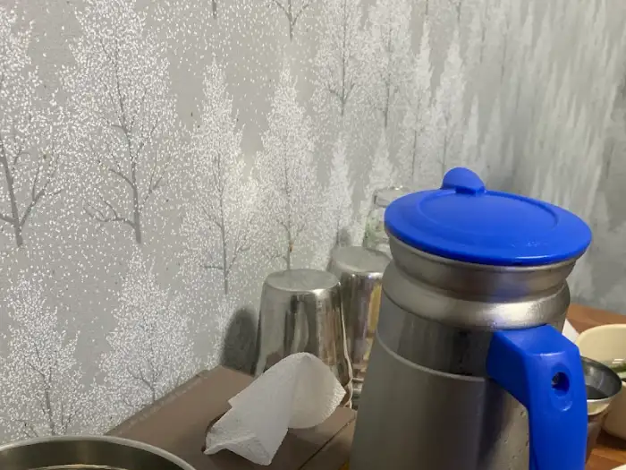 식당 내부 전경, 벽면 그림과 보온병, 컵이 보인다.